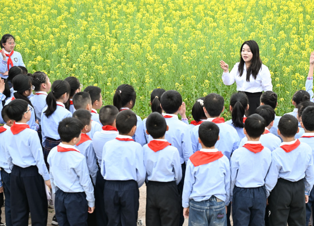 小小礼仪引导员们热心迎接同学们归来大家手持绿色心愿卡